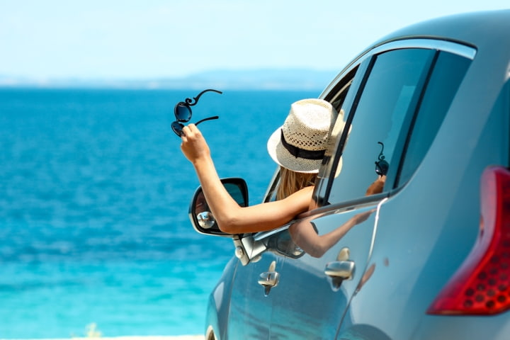 Frau im Auto am Strand